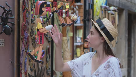 girl exploring wooden puppets in a street market