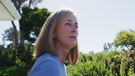 Portrait-of-senior-caucasian-woman-smiling-in-a-sunny-garden