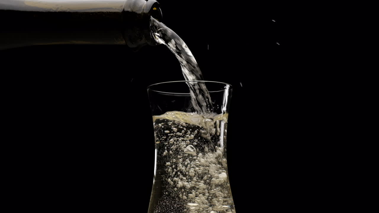 느린 동작으로 검정색 배경에 플루트에 샴페인 와인 프로세코를 붓는