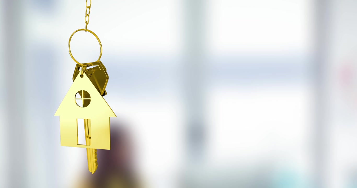 Chiave di casa dorata e portachiavi che simboleggiano una nuova casa.