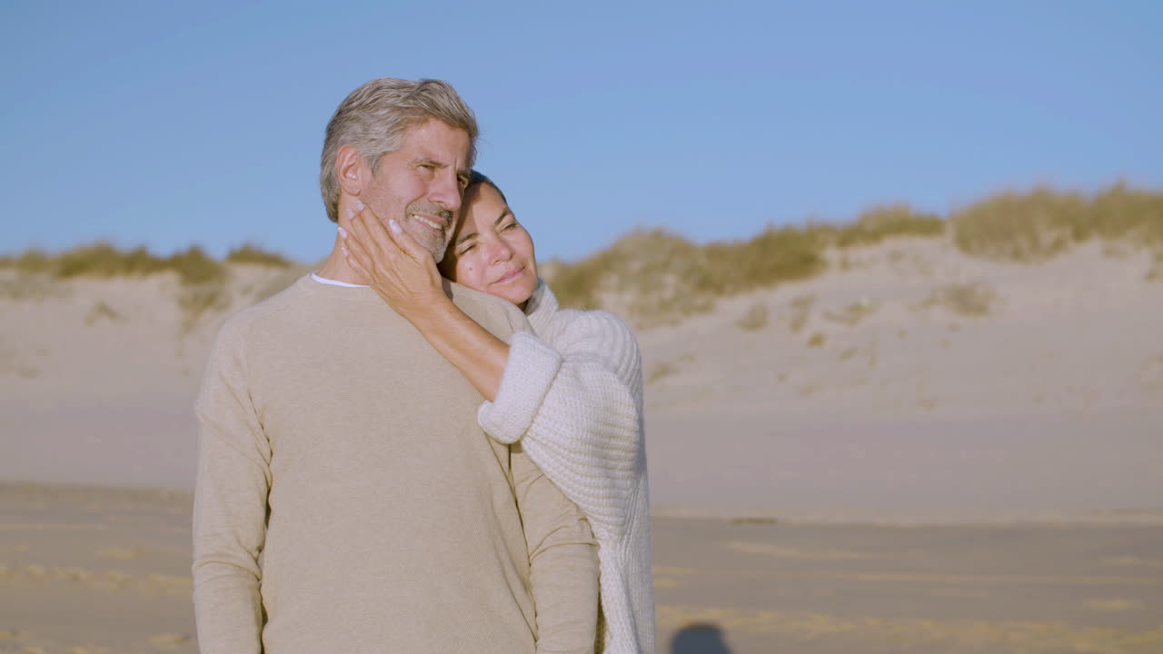 다정한 노부부가 해변에 서서 함께 시간을 즐기는 모습