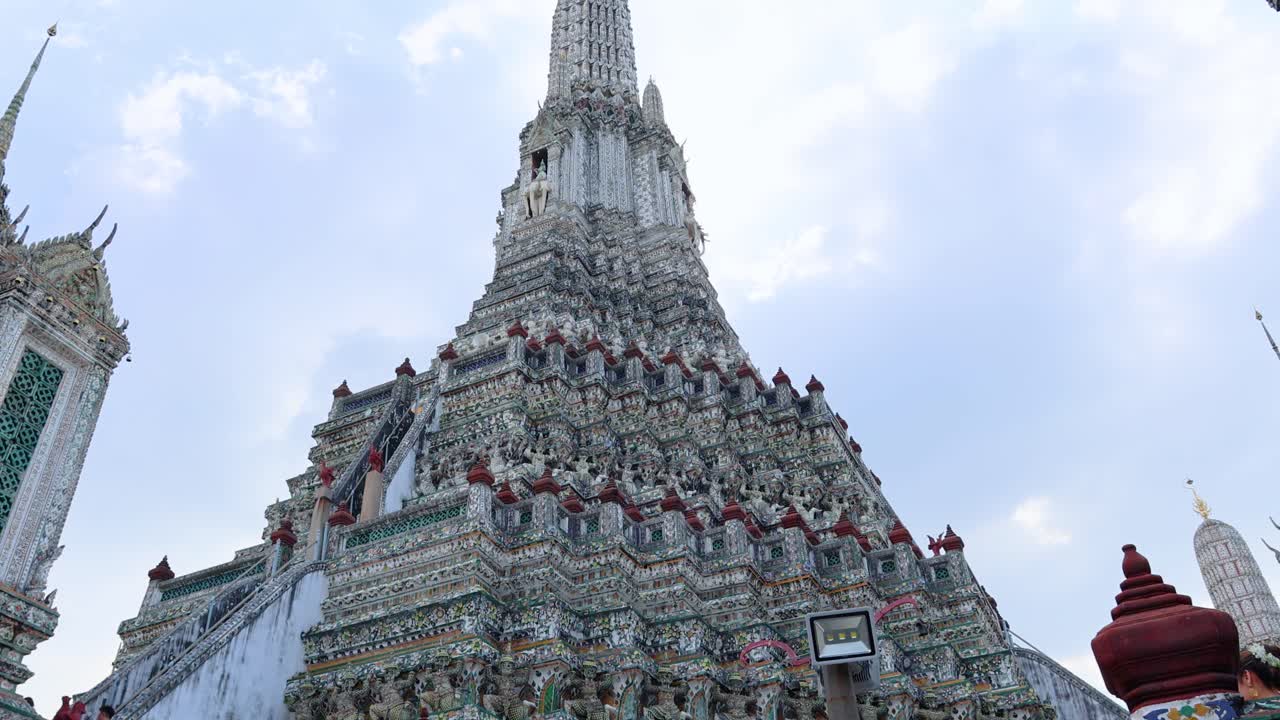 구름이 가득한 하늘을 배경으로 와트 아룬 사원 건축물의 위쪽 전망