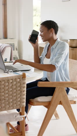 slow-motion video: african american woman multitasks with laptop and smartphone