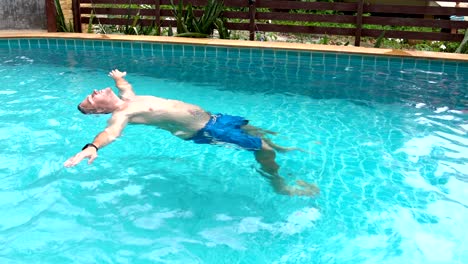 man relaxing in the swimming pool in hotel