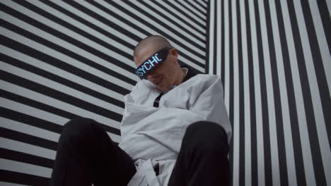 man in restraints and blindfold, optical illusion background