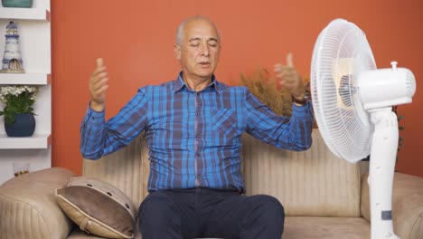 the old man using the fan is overwhelmed by the heat.