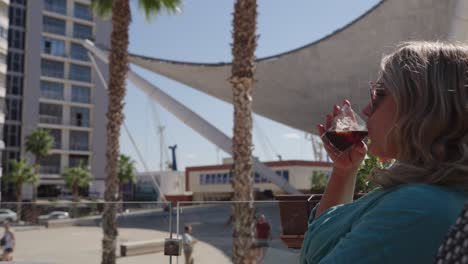 blonde woman in sunglasses sips a coffee at a cafe in durres, albania