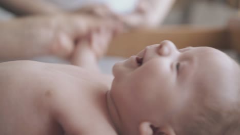 pediatrician flexes and stretches adorable infant boy arms