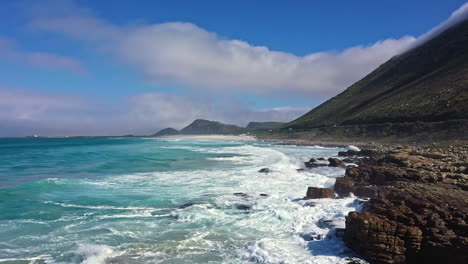 Olas-Rompiendo-En-Las-Rocas-Costa-Sudafricana-Toma-Aérea-Día-Soleado