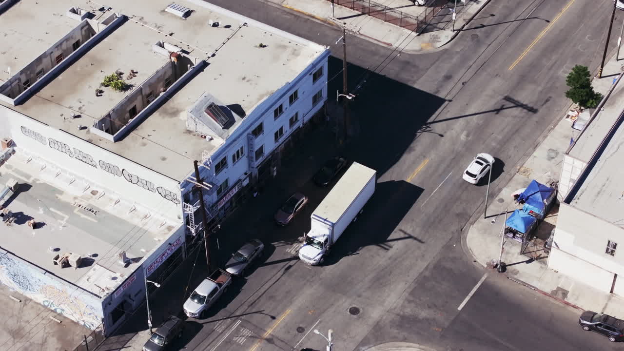 Aerial view of an urban street with buildings and vehicles