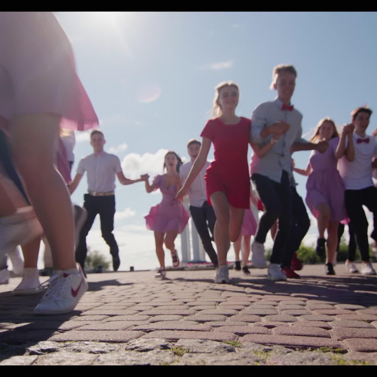한 무리의 잘 차려입은 고교생들이 즐겁게 달리다