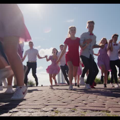 a group of well-dressed high school graduates cheerfully run