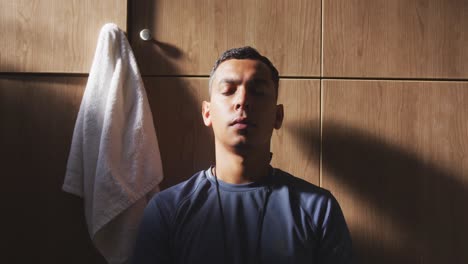 depressed soccer player looking at camera in the locker room