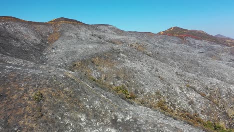 colinas rojas y negras en el sur de california cubiertas de ceniza y retardante de fuego después de un incendio forestal