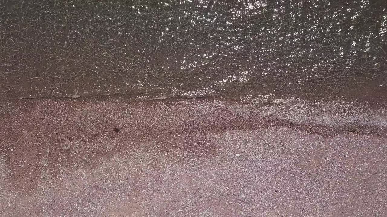 鳥の目から眺める 輝く波が石のビーチを叩く 静的な作物