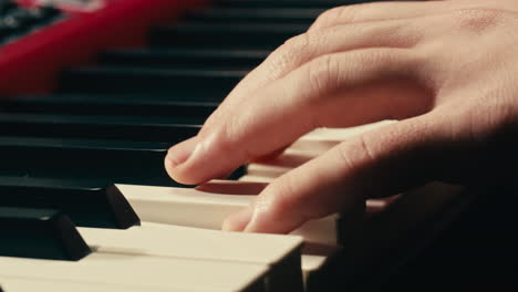 close up of keyboard player hands playing rock music with keyboard at the concert in studio, rehearsal room, macro play on synthesizer.