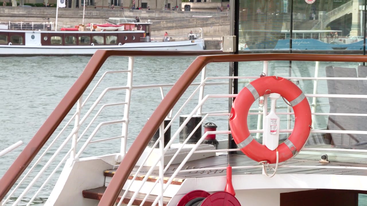 Statische Aufnahme eines Kreuzfahrtschiff-Decks mit Rettungsring und Treppe auf der Seine.