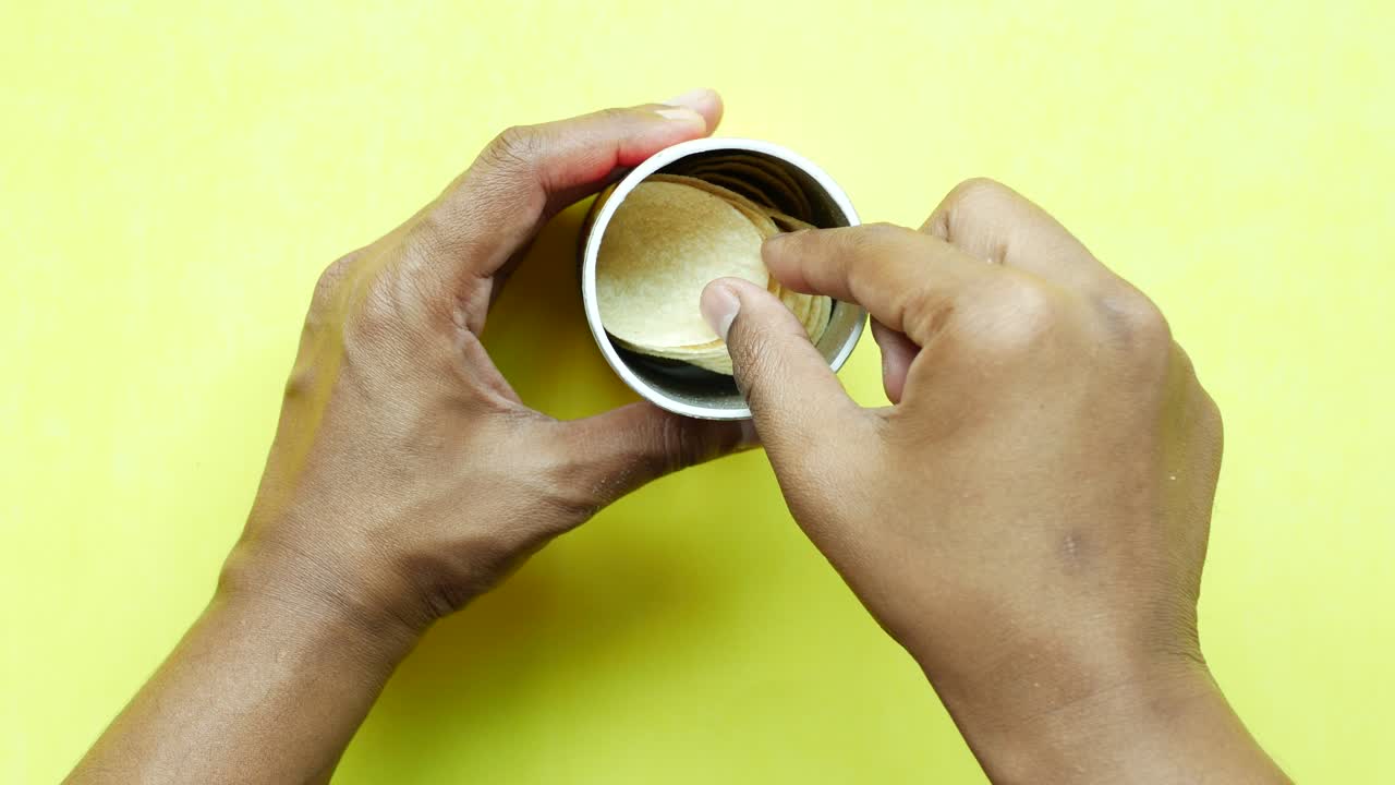 recoger a mano las papas fritas de un recipiente ,
