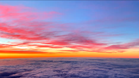 dramatic golden sunrise with beautiful colored clouds as seen from the aircraft flying above overcast clouds