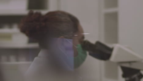 female scientist looks into a microscope in a laboratory