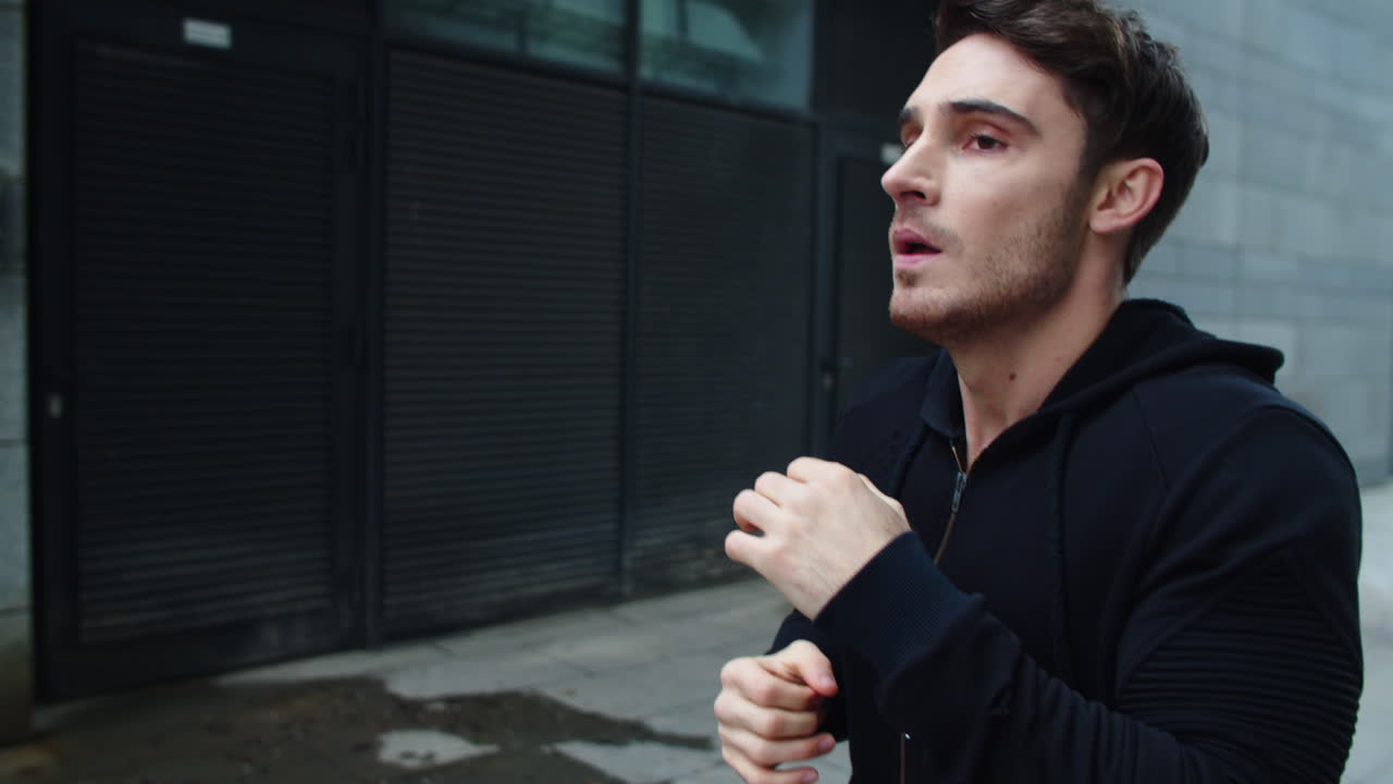 도시 거리에서 달리는 클로즈업 권투 선수. 야외에서 권투하는 전투 선수