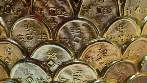 spinning coin-shaped gold decorations with asian characters, close-up