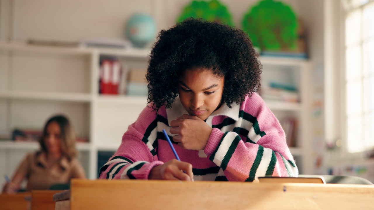 A student writing in a classroom