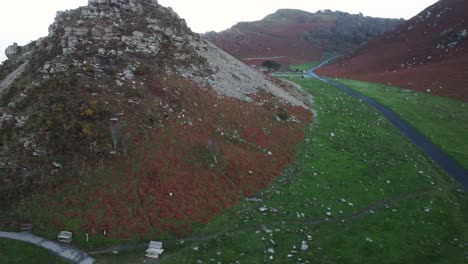 Seitwärtsaufnahme-Entlang-Der-Dramatischen-Klippenspitze-Im-Tal-Der-Felsen-Mit-Sitzbänken-In-Exmoor,-Großbritannien-–-Luftaufnahme