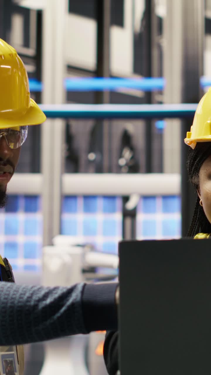 Vertical video Engineering team working together in photovoltaics factory, looking at metrics
