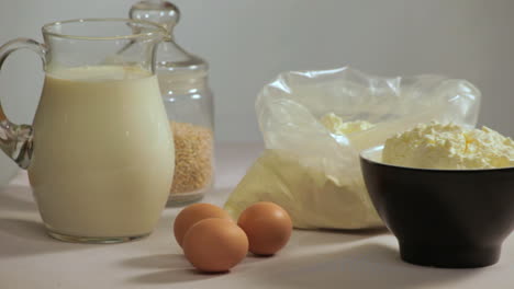 milk and eggs on table. organic ingredients for cooking. baking ingredients