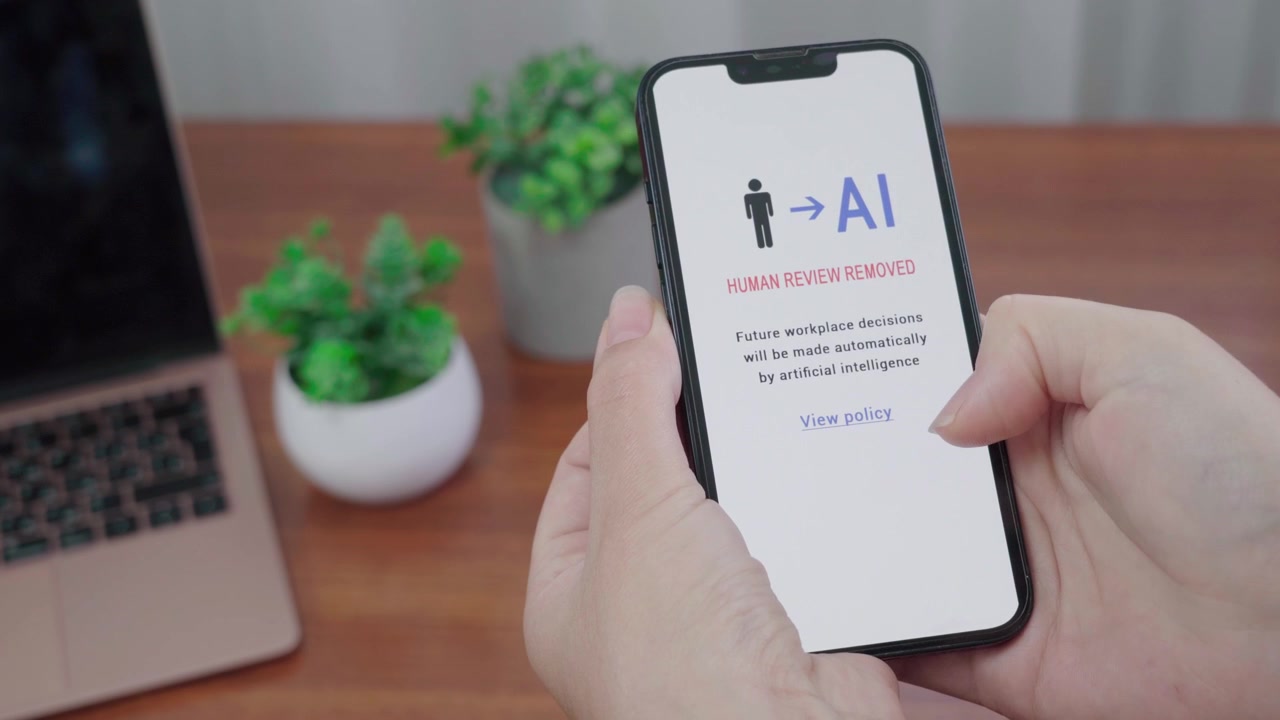 User reads a mobile notice stating human review is removed and future workplace decisions will be made by AI.