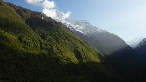 Rotating-drone-shot-of-the-sun-shining-on-the-face-of-the-Annapurna-mountains,-Nepal