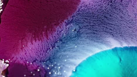 tinta púrpura y azul vibrante difundida en el agua, creando una textura abstracta y fluida