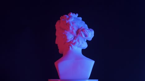 ancient bust under neon lighting