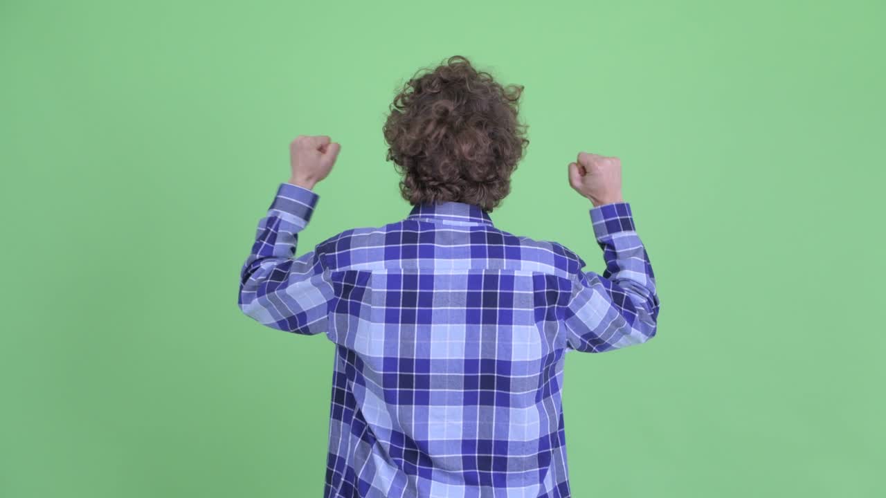 un joven guapo, barbudo y hipster con el cabello rizado.
