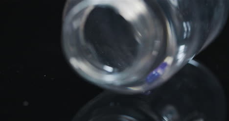 píldora médica única en botella pequeña girando sobre fondo negro 3