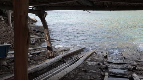 Zeitlupe-Der-Wellen,-Die-Im-Alten-Bootshaus-An-Einem-Tropischen-Strand-Plätschern