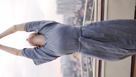 Happy-blonde-woman-at-terrace-making-Namaste-gesture-by-her-hands