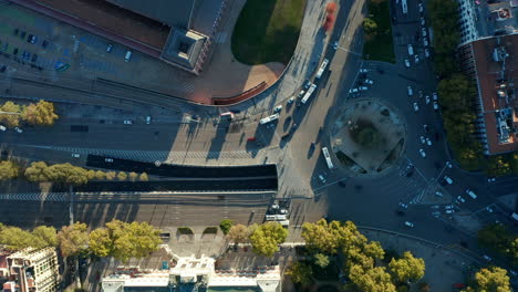 Aerial-birds-eye-overhead-top-down-view-of-vehicles-driving-in-city,-passing-through-large-roundabout.-Rush-hour-on-crossroads.