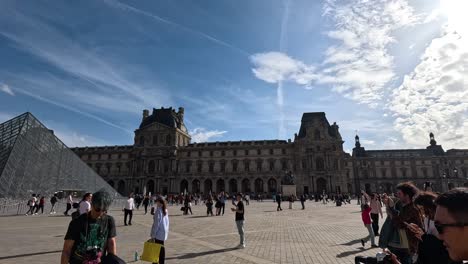 tourists exploring the louvre pyramid courtyard