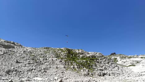 helicopter flying to a mountain hut with supplies