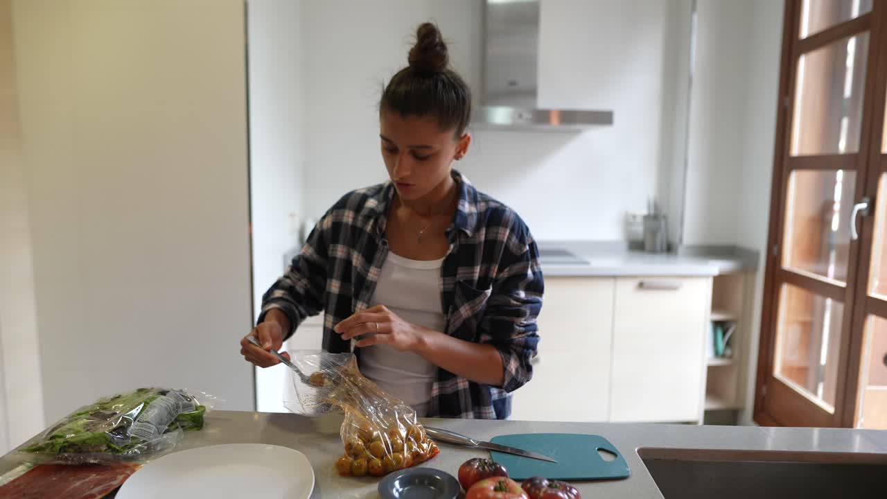 mujer preparando y comiendo tomates encurtidos en la cocina
