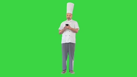 chef masculino haciendo una llamada de video en un teléfono inteligente en una pantalla verde, clave de croma