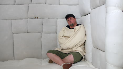 Man in a straitjacket in a padded room
