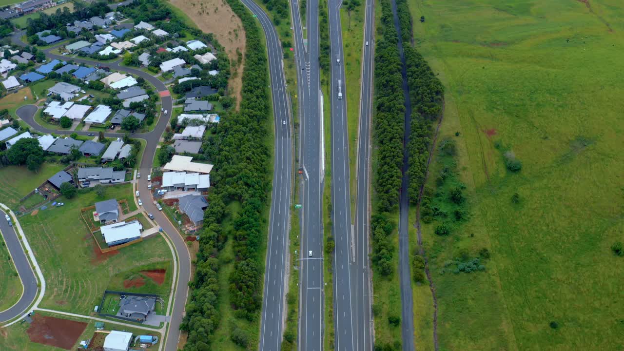 바이런 베이와 브리즈번, 퀸즐랜드, 호주를 연결하는 무성한 들판에 있는 전형적인 집 근처의 태평양 고속도로 차도에서 운전하는 차량