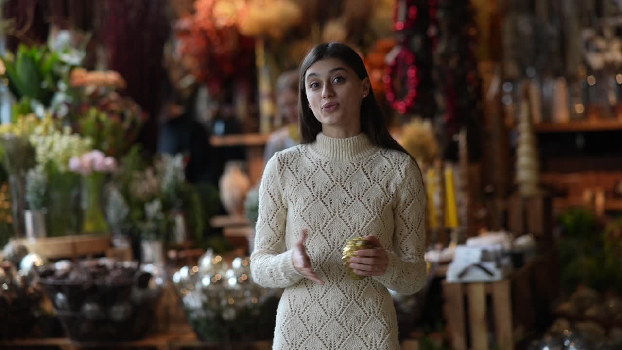 꽃 가게 에서 크리스마스 장식품 을 전시 하는 여자