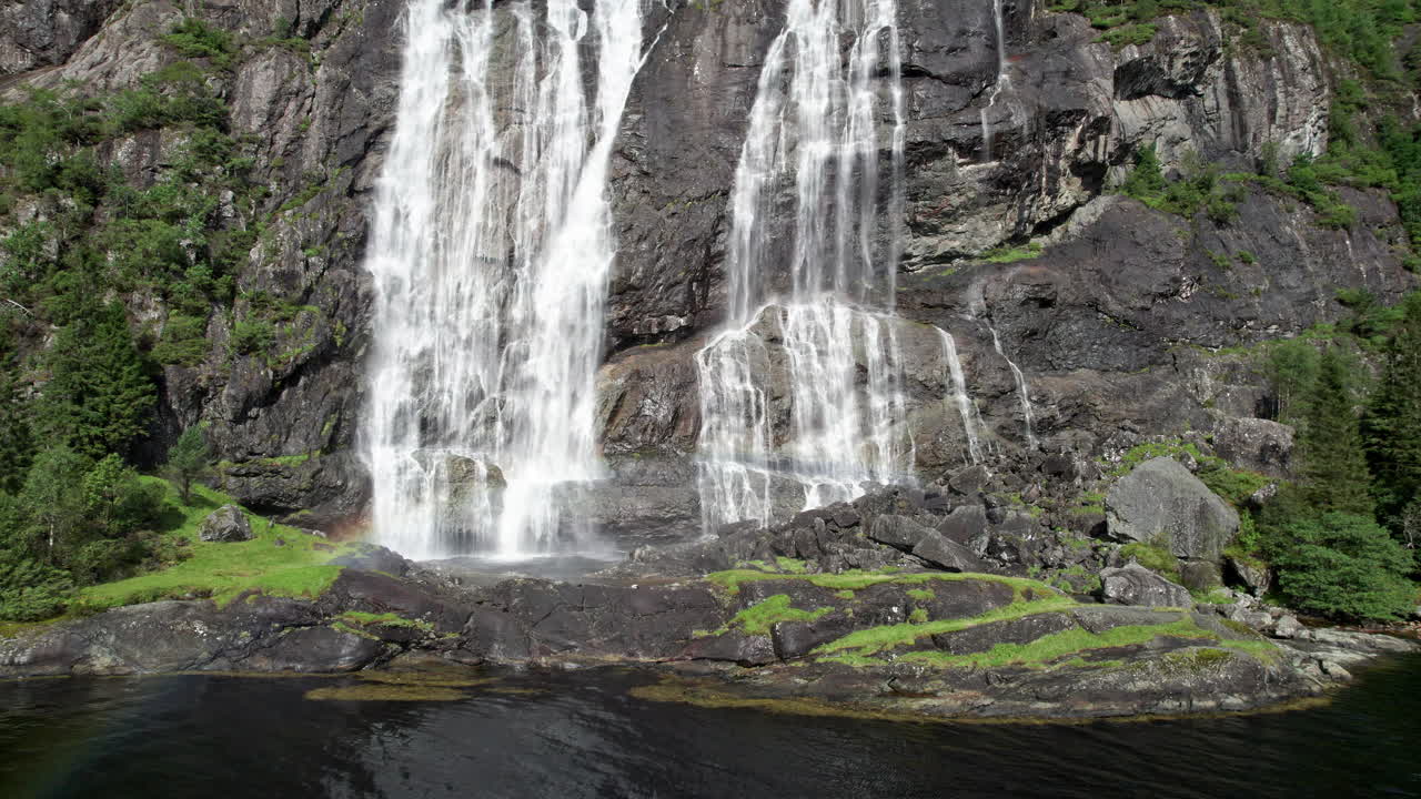 Camera pushes in on the bottom of a large waterfall, Laukelandsfossen, in Norway