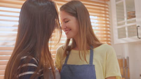 dos mujeres besándose en una cocina
