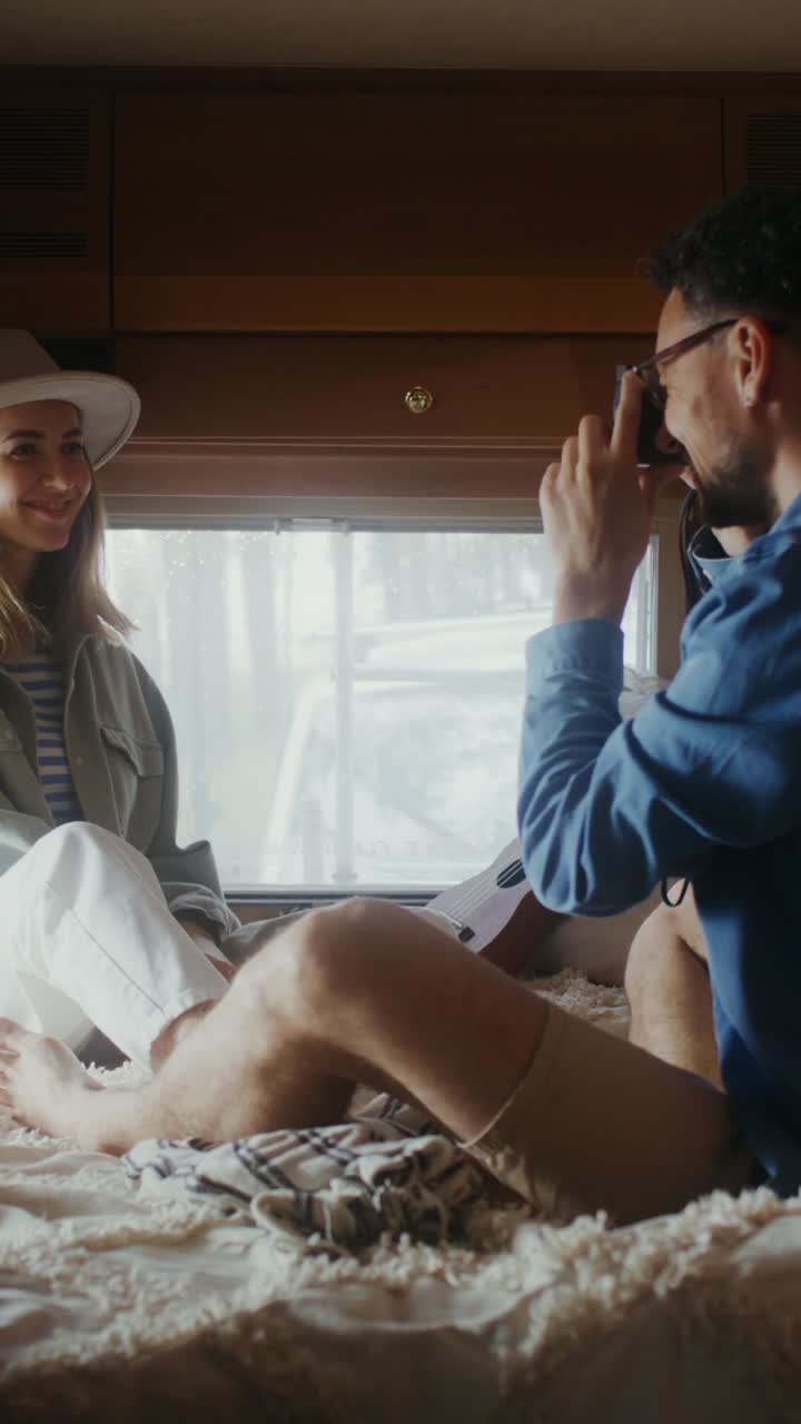 커플 이 캠퍼 밴 안 에서 사진 을 찍고 있다