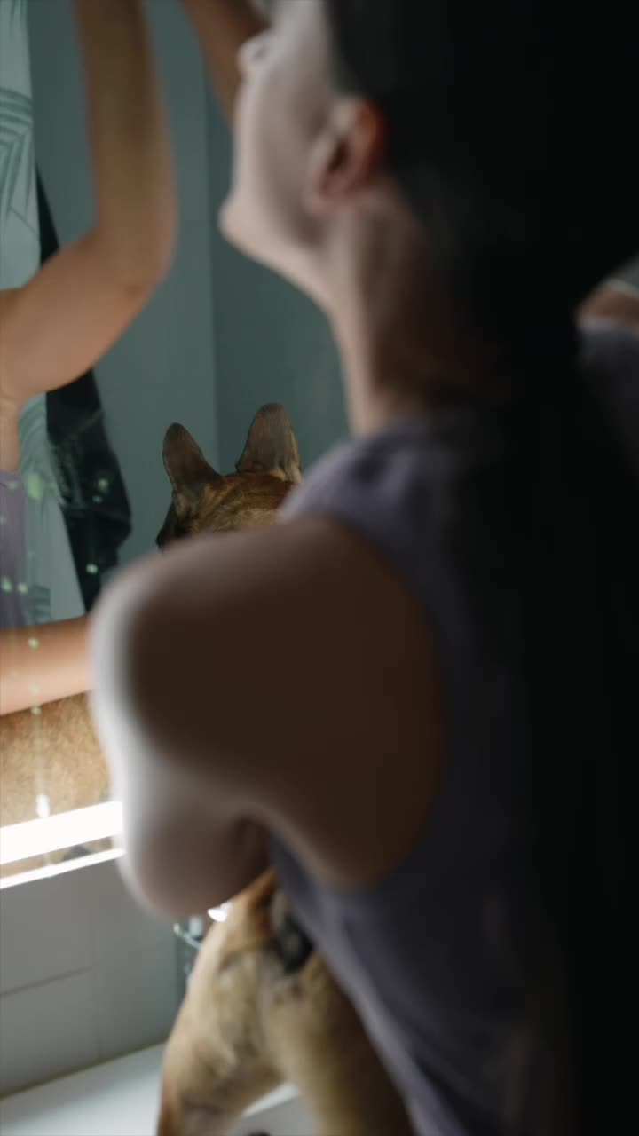 Woman washes a dog in front of the mirror
